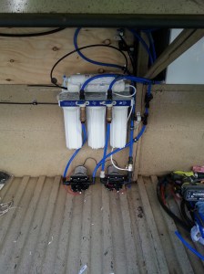 Water supply system, the filtration system directly above the 2 pumps & the timber containment walls for the Non-potable water bladder above & left. The rear end of the Poly tank for the potable water is visible to the right, both of these tanks sit over the chassis rails between the RH & LH Bins.